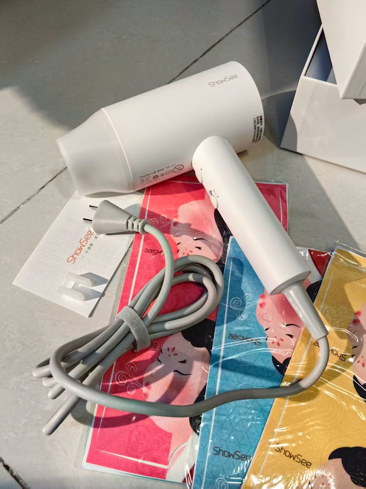 Bên trong là sản phẩm Máy sấy tóc iON âm Xiaomi SHOWSEE A1-W 1800W và Logo và miếng dán với các phiên bản khác nhau